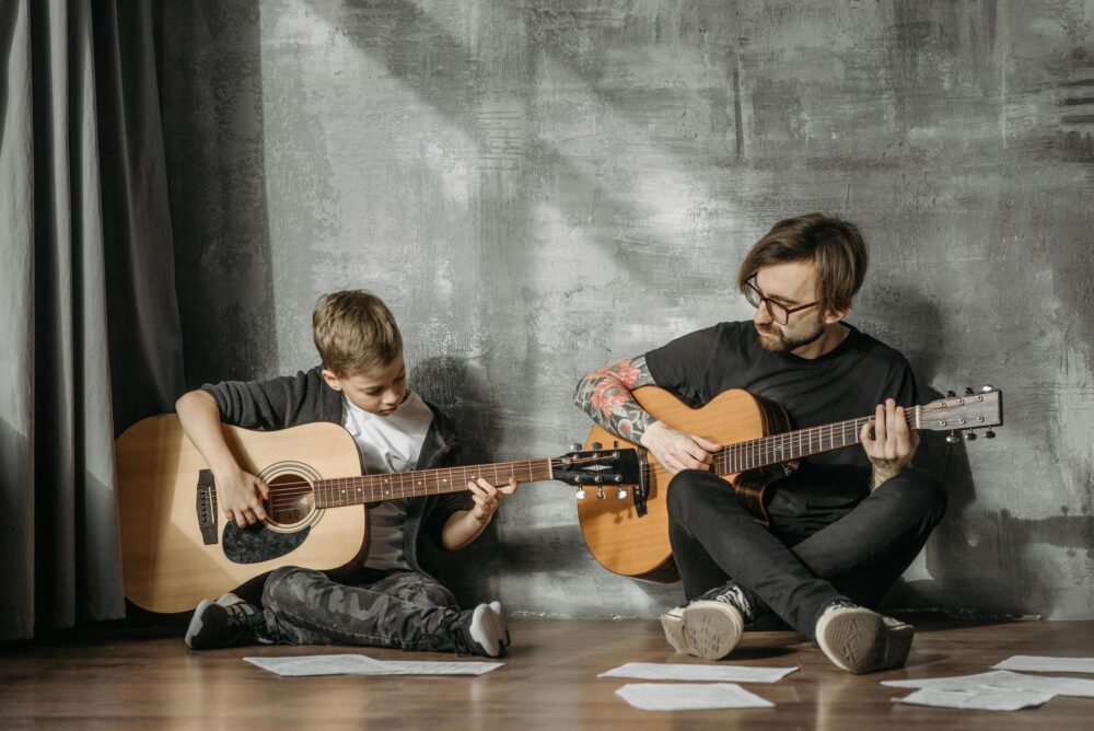 Two guitar players showing one of their hobbies